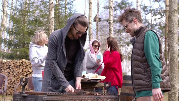 Men Grill Meat on Nature in Spring Sunny Day. People Communicate at a Picnic