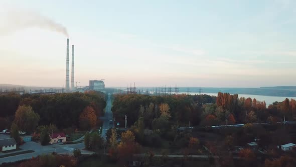 view of the power station with two pipes and with road to it with the planting of trees alt
