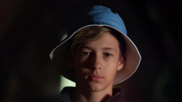 Portrait of a Sad Boy in a Hat Looking at the Camera Indoors Moving Camera Boy Looks Up and Looks at