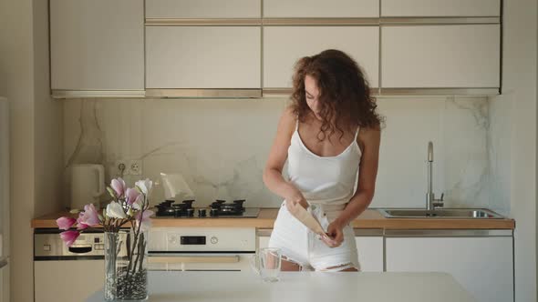 A Young Woman Pours Tea Into a Cup