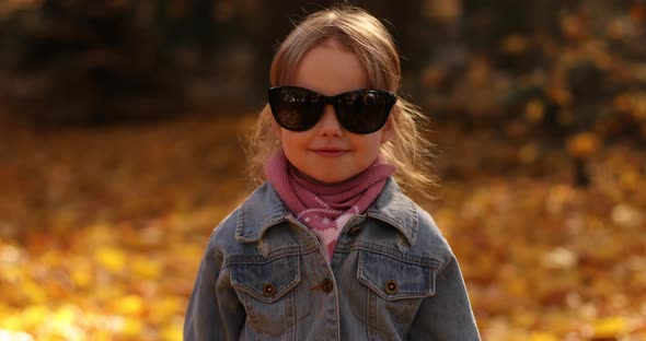 Pretty Little Girl in Black Mum's Sunglasses Smiles and Rejoices