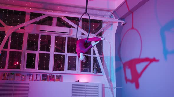 Aerial Gymnast Performs Beautiful Dance Number on the Ring in Pink Neon Lighting alt