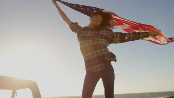 Woman waving american flag on pickup truck at beach 4k alt