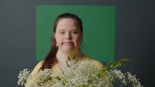 Portrait of Pretty Girl with Down Syndrome Holding Flowers alt
