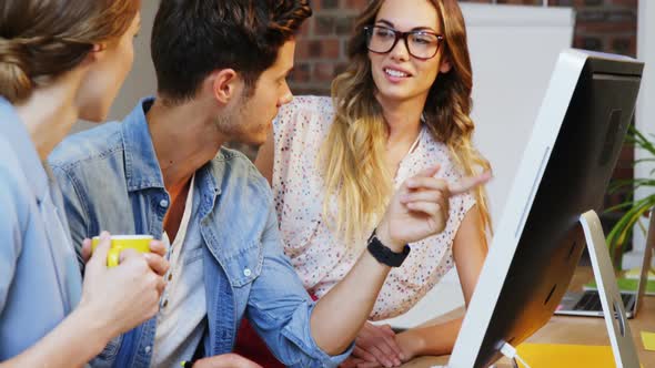 Group of graphic designer interacting over graphic tablet and computer alt