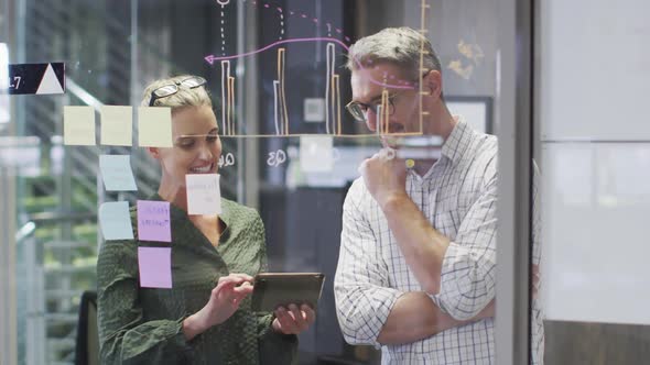 Video of happy caucasian female and male designers brainstorming in office alt