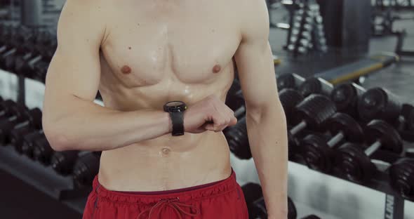 Athlete Looks at His Watch