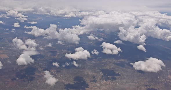 The View From the Plane of Fluffy Clouds in Desert Mountains From an Airplane New Mexico USA alt