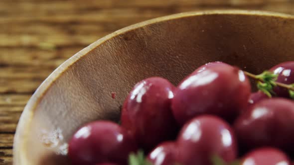 Fresh red olives and rosemary in a bowl alt