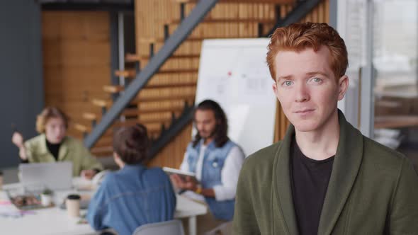 Portrait of Happy Young Businessman Posing in Workplace alt