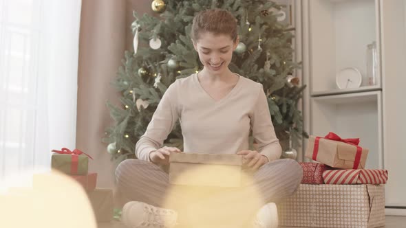 Young Woman Opening Christmas Gift alt