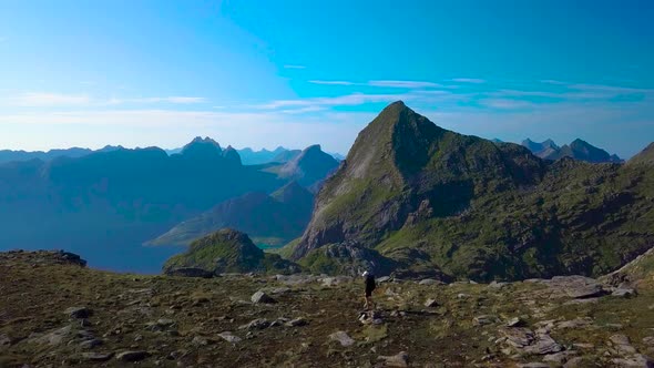 Aerial View of Girl with a Backpack Goes on a Mountain Ridge alt