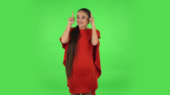 Pretty Young Woman Is Pointing Up Fingers alt