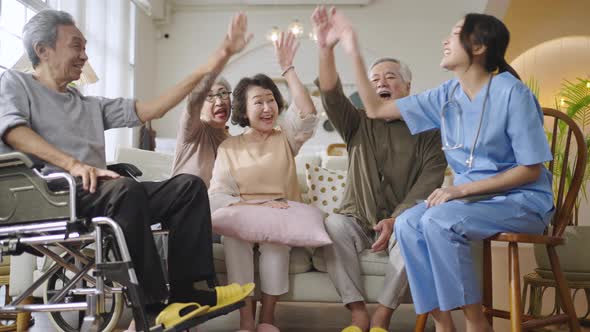 Group of Asian senior people in nursing home forming hands stack to build morale for yourself alt