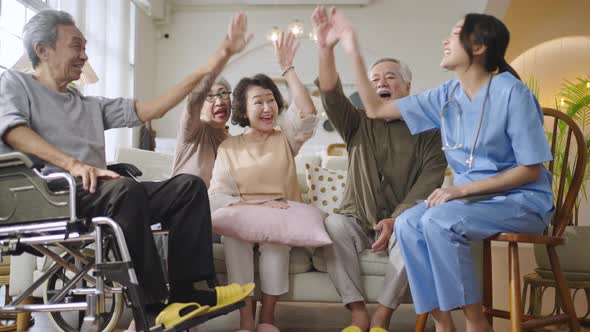 Group of Asian senior people in nursing home forming hands stack to build morale for yourself