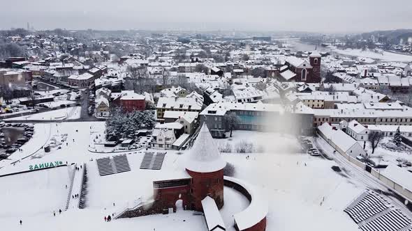 Kaunas city skyline and medieval castle during winter season and snowstorm, aerial view alt