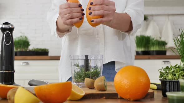 Closeup of a Woman's Hand Squeezing Orange Juice to Make a Wheat Juice ...