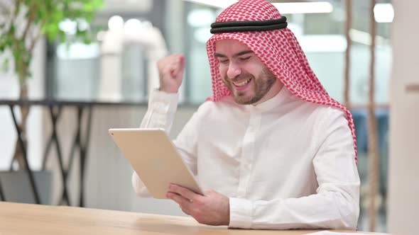 Successful Arab Businessman Celebrating on Tablet in Office alt