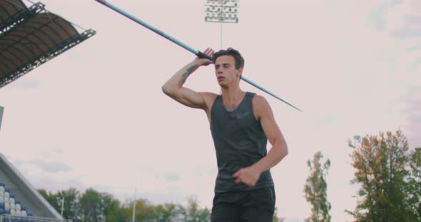 A Male Athlete Throws Javelins at a Stadium in Slow Motion. Athletics Javelin Throw Olympic Program alt