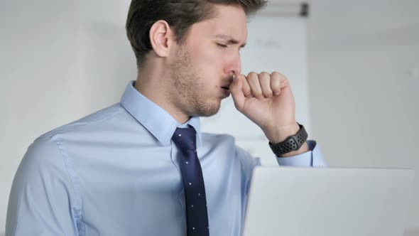Close Up of Young Businessman Coughing at Work alt