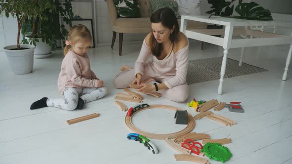 Mother and Daughter Playing with Railroad Toy alt
