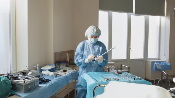 Portrait of Female Medical Worker in Protective Mask Preparing for Surgery alt