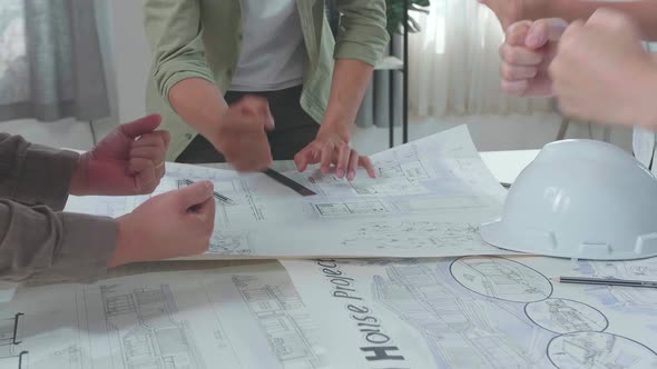 Close Up Of Group Of Asian Engineers Celebrating Finish Working At The Office alt