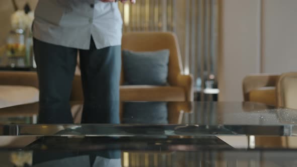 The Maid Puts a Vase of Fresh Flowers on the Table alt