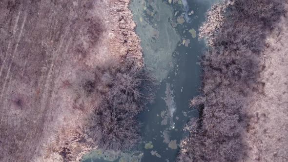 Aerial view of a river channel with ice remnants after the winter season.