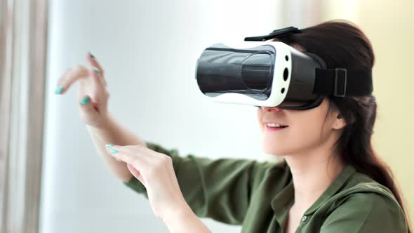 Amazed Young European Woman Wearing Vr Mask Glasses Making Gesture Turning Page By Hands alt