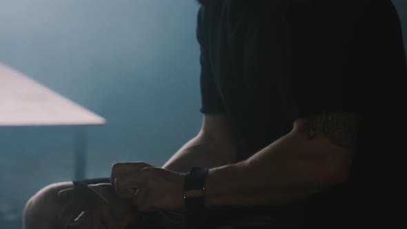 Closeup Muscular Shirtless Caucasian Young Sportsman Sitting Alone in Dark Gym Locker Room Stressed alt