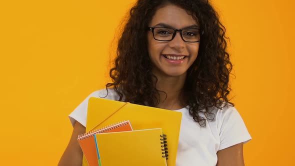 Smart College Student in Eyeglasses Holding Books Yellow Background, Education alt