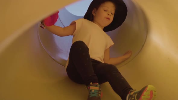 Slow motion. Little girl playing on kids playground in urban park. alt
