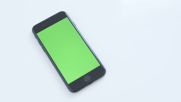 ZAJECAR, SERBIA - NOVEMBER 2016 Chroma key modern phone with green screen slow tilt on white backgro