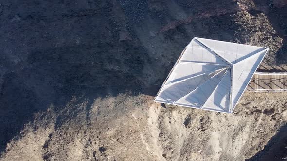 Aerial sliding to the right slow drone shot of a lookout point on a ridge near Eilat, with white fen alt