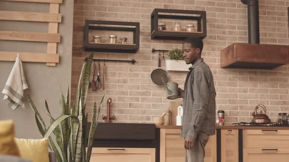 Man Watering Home Plants alt