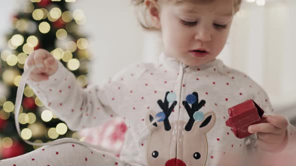 Video of toddler unwrapping tiny Christmas gift. Shot with RED helium camera in 8K alt