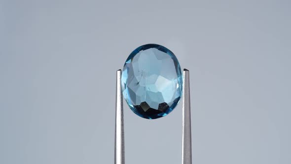 Natural Blue Topaz Oval Cut in the Turning Tweezers