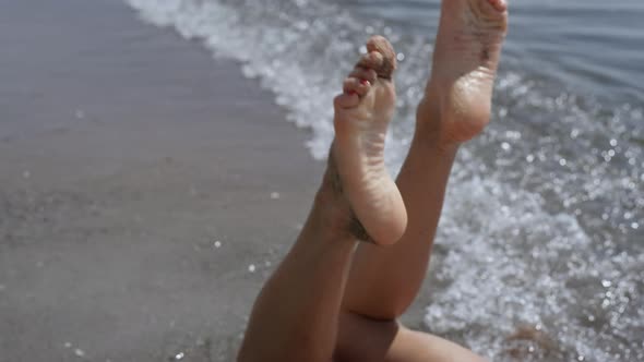 Closeup Woman Legs Waving in Front Ocean Waves Sunny Day alt