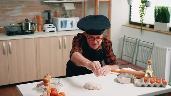 Professional Chef Sprinkling Flour on Dough alt