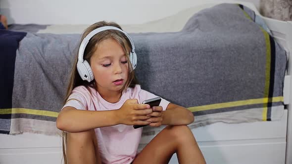 Cheerful Child Listening to Music in Headphones