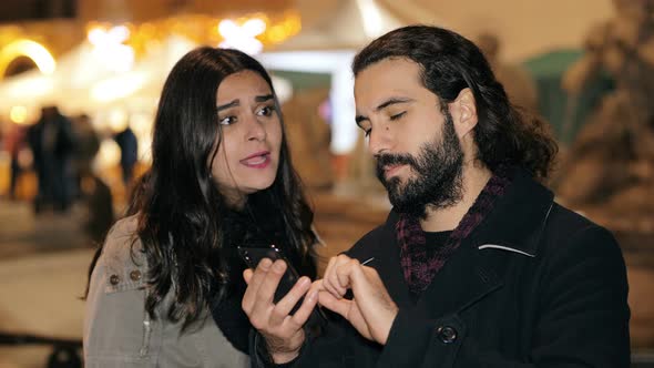 angry woman arguing with her boyfriend using smartphone,throwing it on ground alt