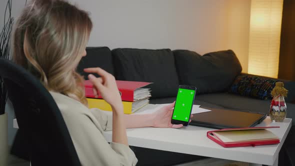 Back View of Woman at Phone with Green Screen alt