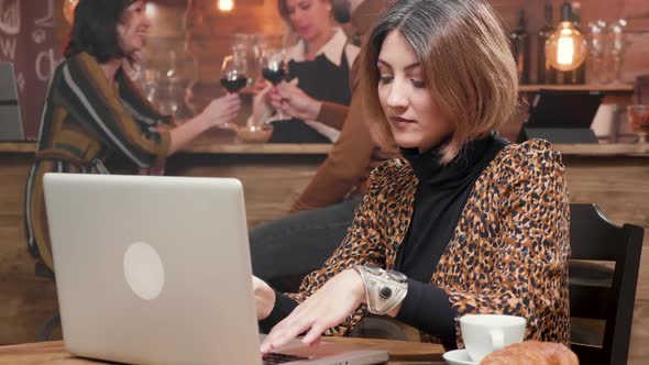 Woman Entrepreneur Typing a Text on Her Laptop While Working in a Coffee Shop alt
