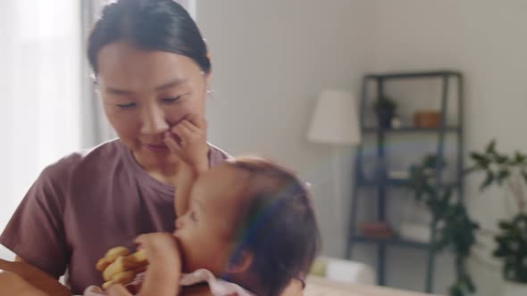 Asian Mom Having Fun with Joyous Baby Girl at Home alt