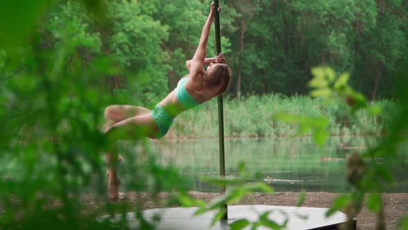 Woman Doing Splits on Background Forest and Lake. Slim Young Girl Pole Dancer alt