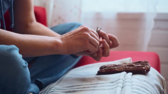 Close Up of a Young Man Cutting His Toenails in the Living Room alt
