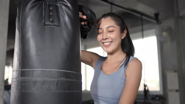 4K Asian sportswoman in sportswear wearing boxing gloves do boxing exercise at gym. alt