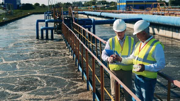 Wastewater Operators Checking Water Condition at a Sewage Treatment Plant alt