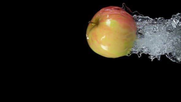 An Apple is Bouncing Horizontally From Water with Splashes on a Black ...